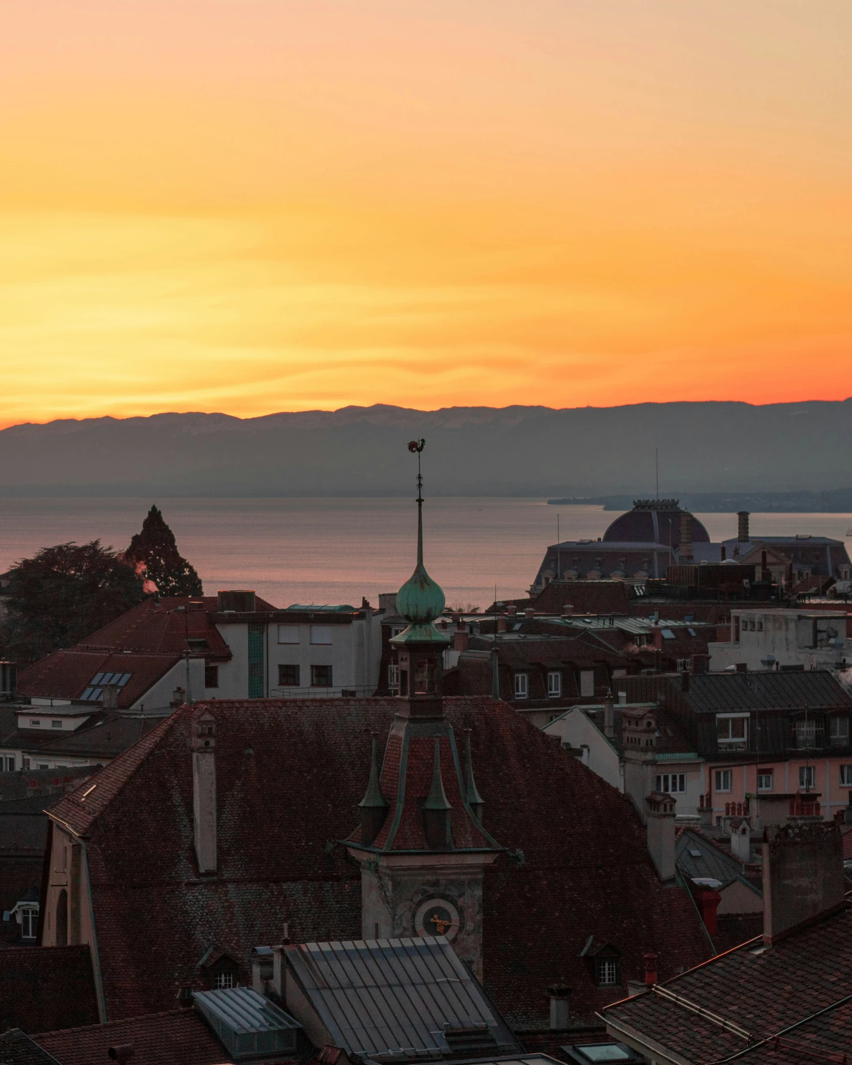 sunset over a city, with mountains in the background