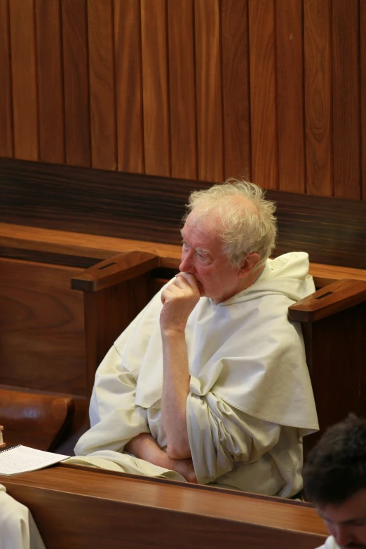 a man with white robes is sitting in court