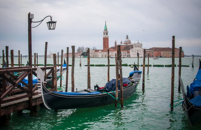 two boats tied to the pier with a clock tower in the background