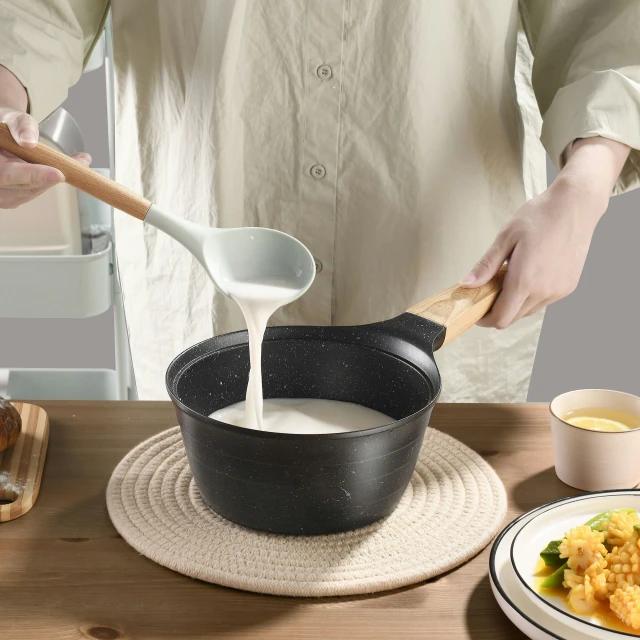 a person pouring milk into a pot filled with food