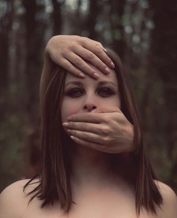 a woman covering her face and touching her cheeks