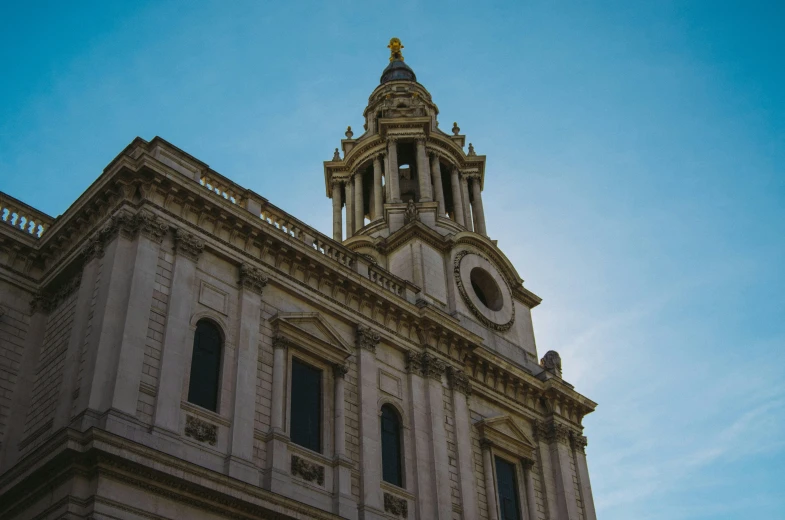 a white building with a gold clock at the top