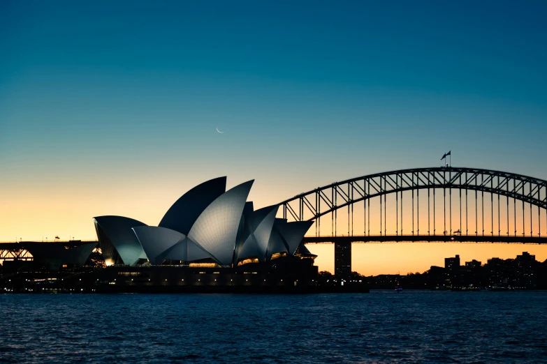 view of the sydney opera house and the sydney harbour bridge, taken in front of a silhouette of sydney