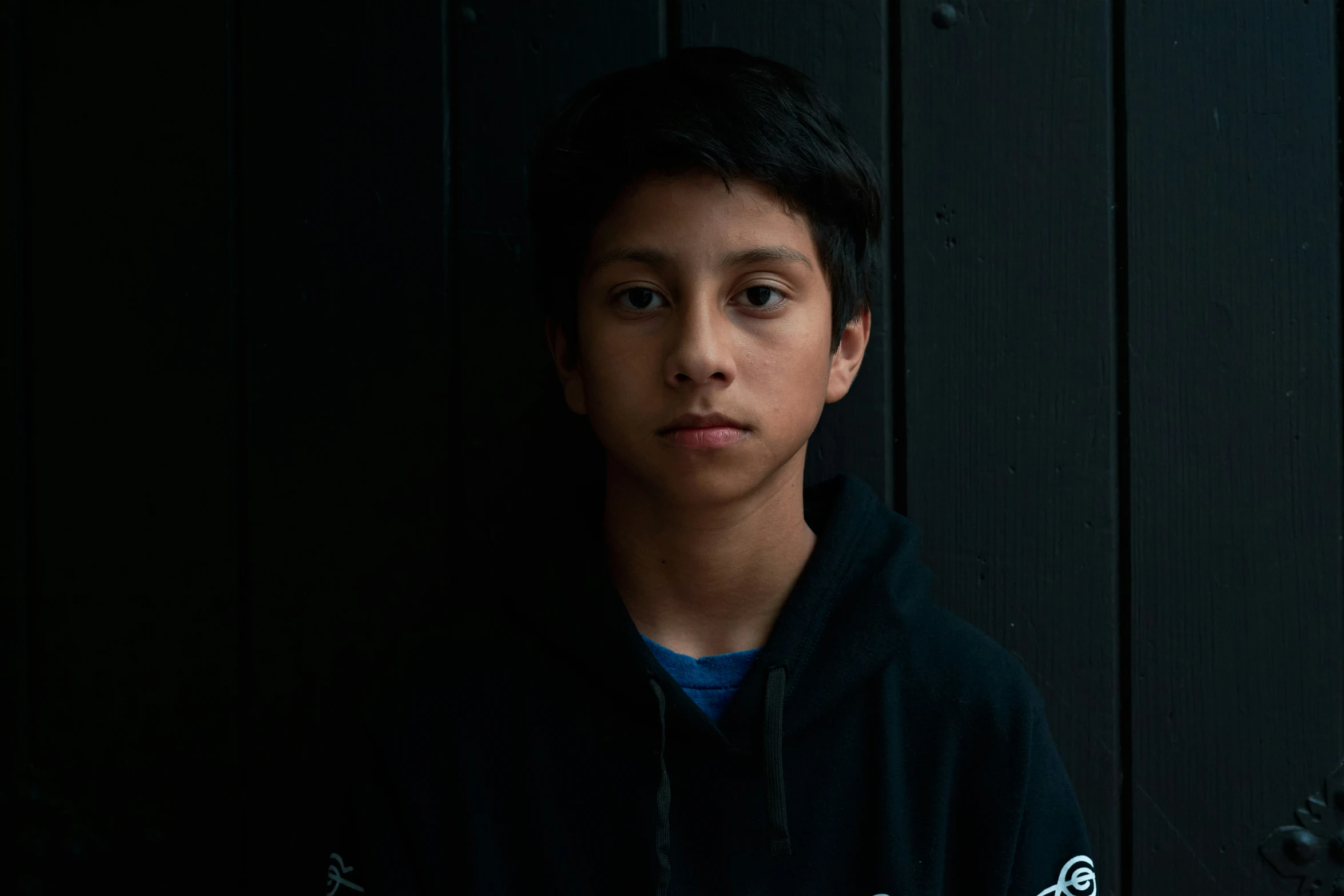 a boy in the dark posing for a picture