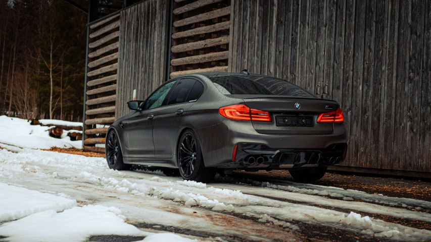 a silver car sitting in front of a wooden building