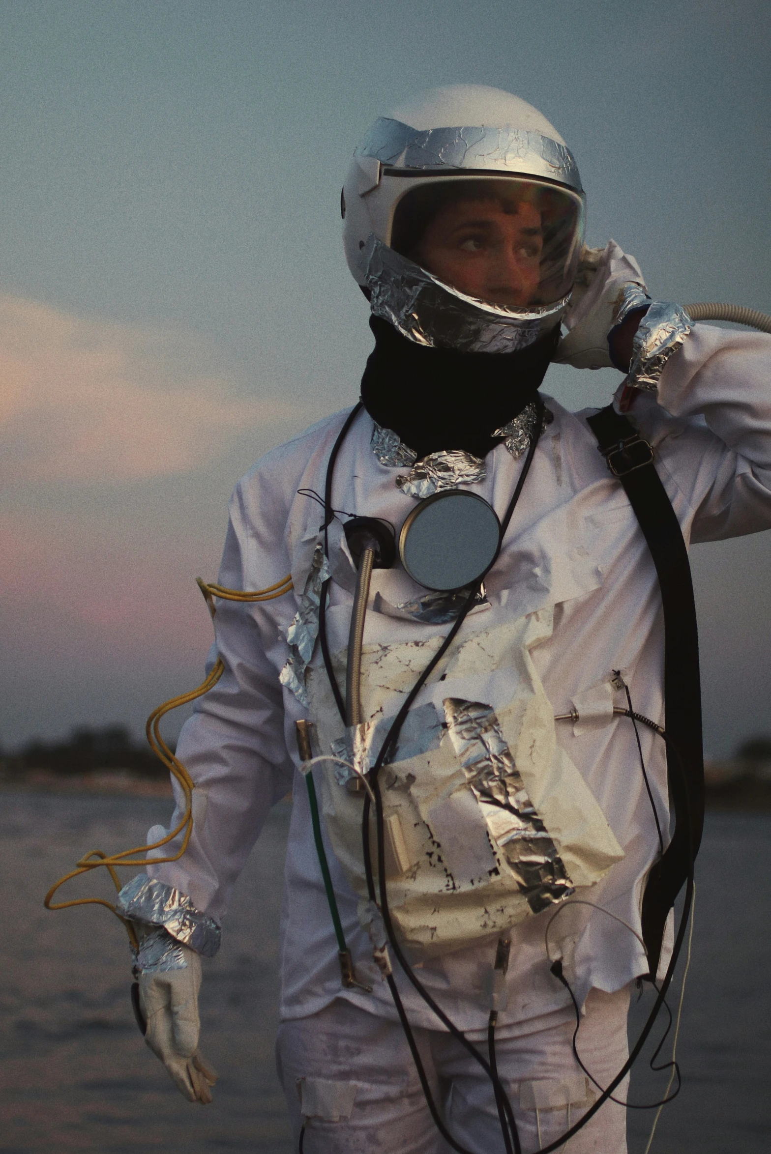 an astronaut is talking on his cellphone while walking along the water