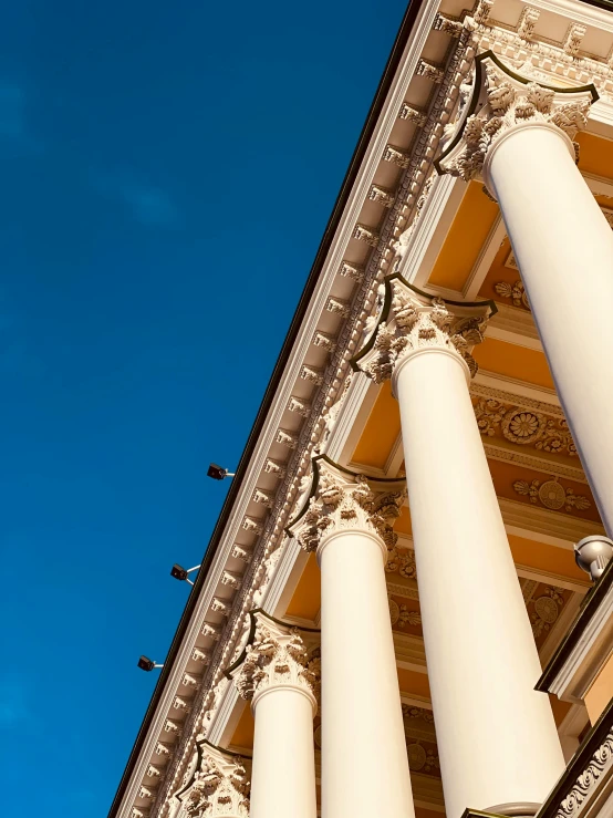 an ornate building with several pillars and birds flying by