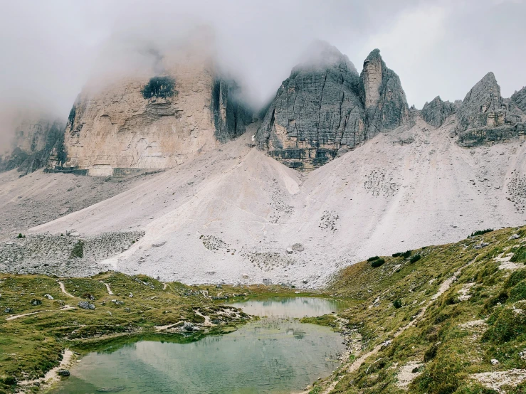 some mountains with water and clouds in the background