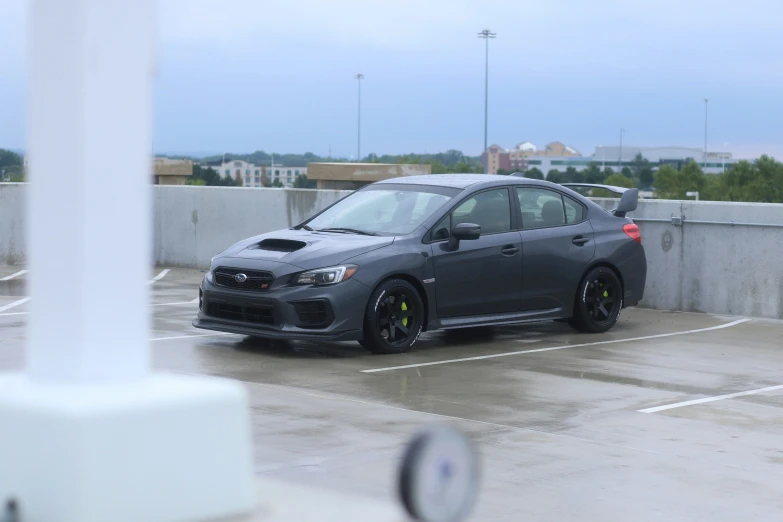 a grey car is parked in an open parking lot