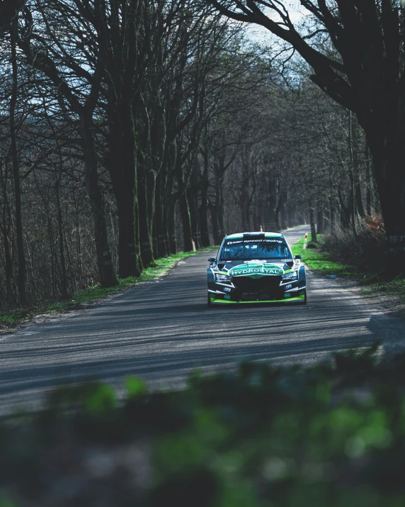 a car driving down the road in front of trees