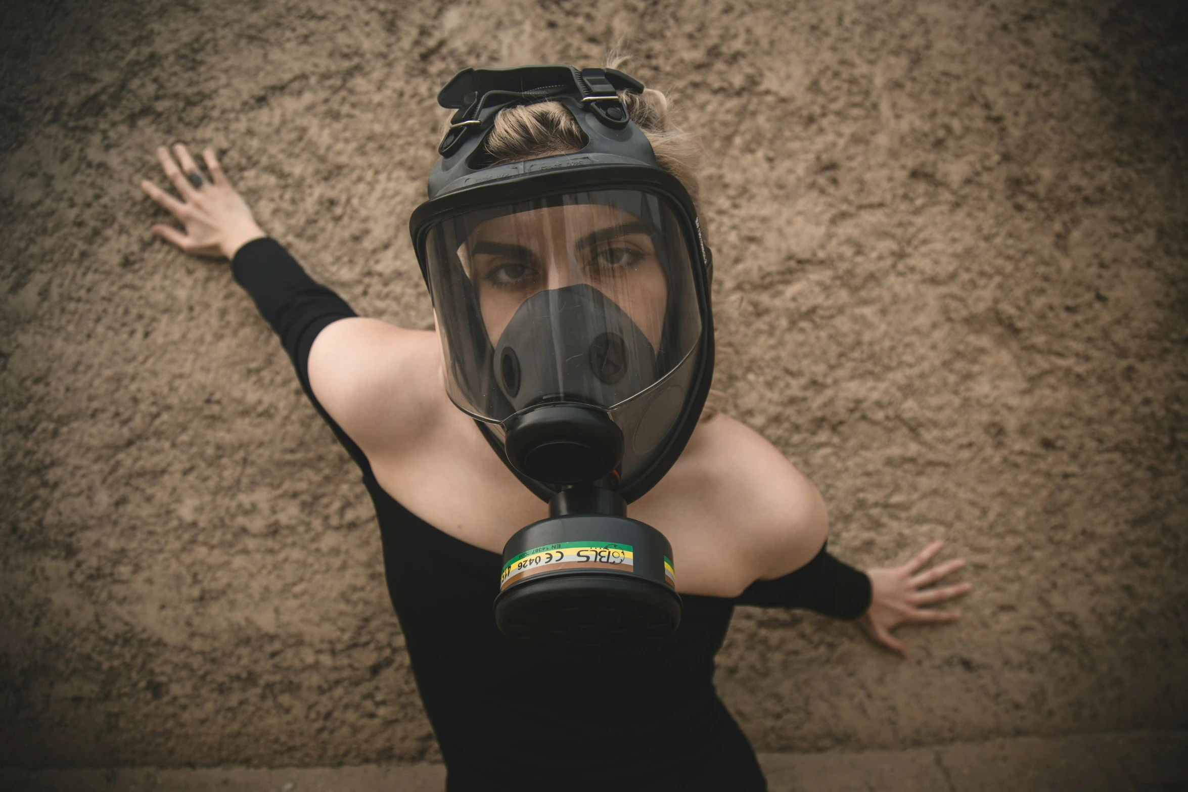 a woman in black wearing a gas mask