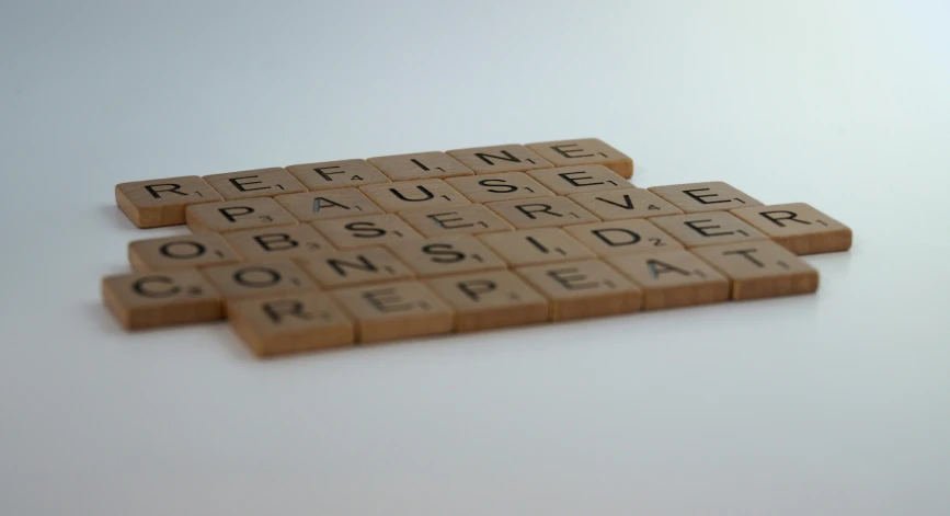 two scrabble pieces of wood spelling the names of various countries