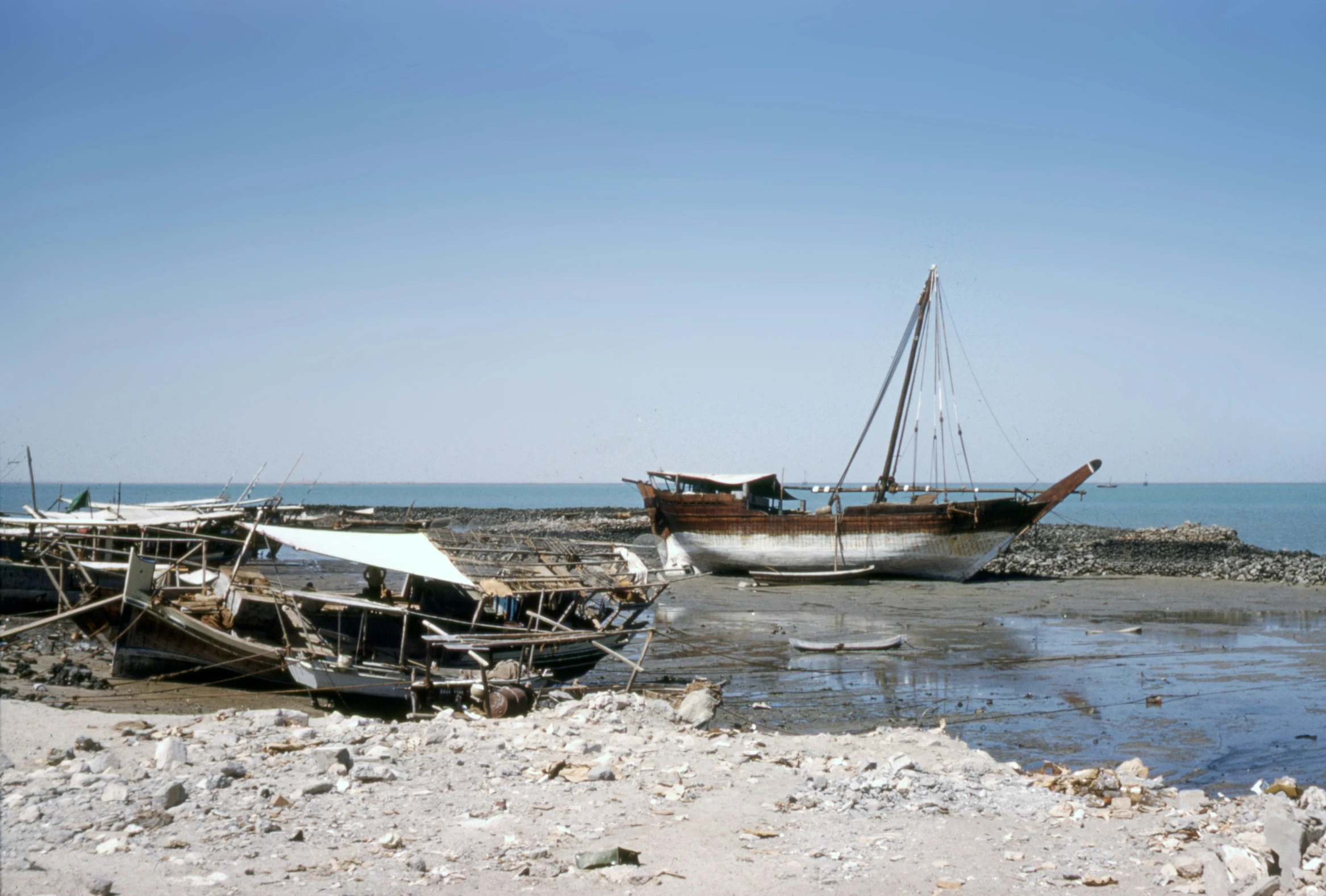 boats moored on rocky shore with ocean behind