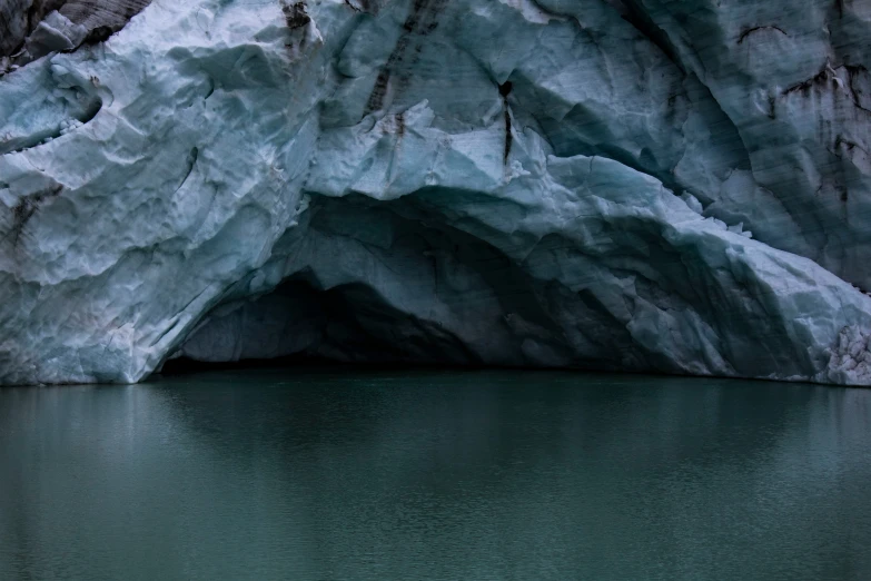 people paddling on small boats in a boat by a glacier