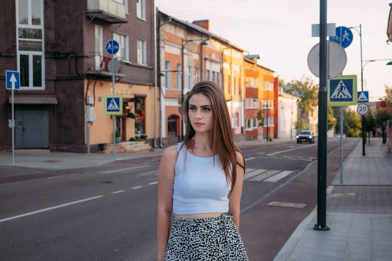 the girl is posing in front of some buildings