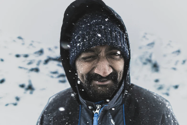 man wearing a winter coat and looking at the camera