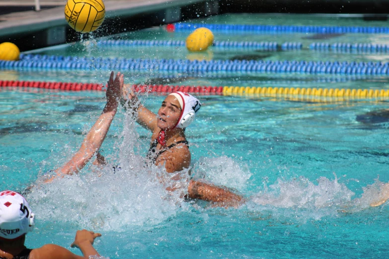 a women playing a game of water polo in an empty pool