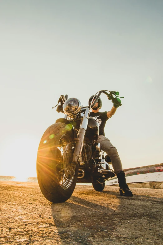 a motorcyclist sits on his bike in the sun