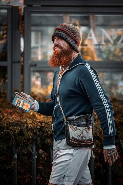 a bearded man carrying a water bottle with soing in his hand