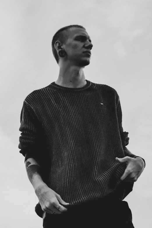 man in black sweater against white background standing