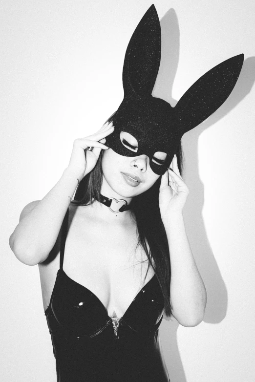 a woman wearing a mask poses with a bunny ears