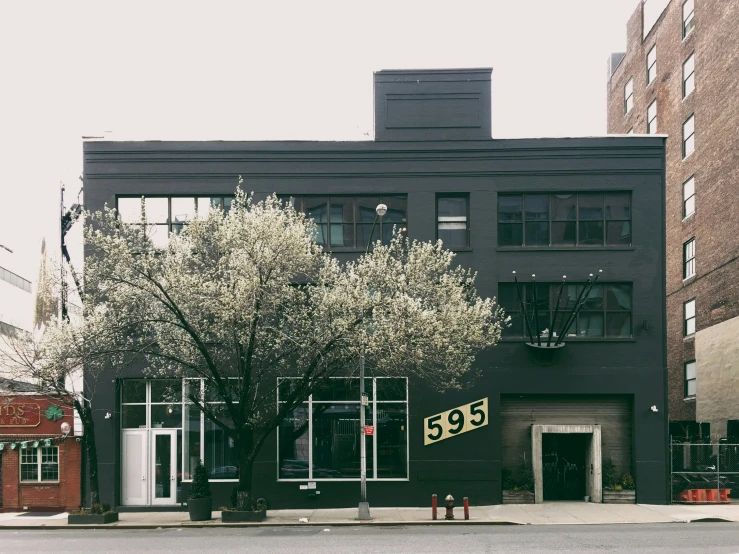 a black building with two floors and white doors on a city street