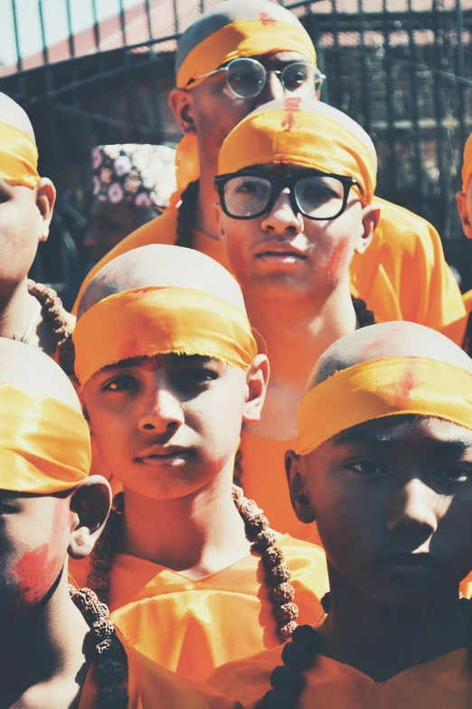 several people in bright yellow headscarves and orange bandanas