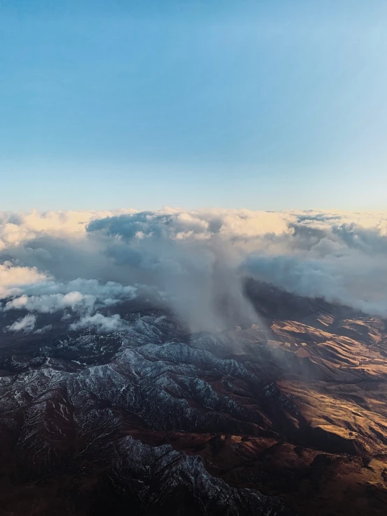 there are clouds in the sky over a mountain top