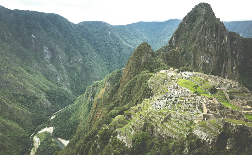 the ruins of ancient incas overlooking a river and mountains