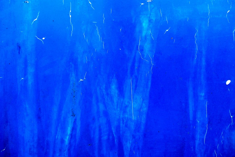 blue water is very dark blue and the background shows a sea floor with light streaks