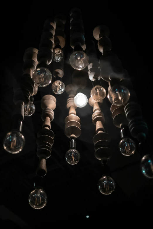 the lights are lit on a chandelier that has glass bulbs all over it