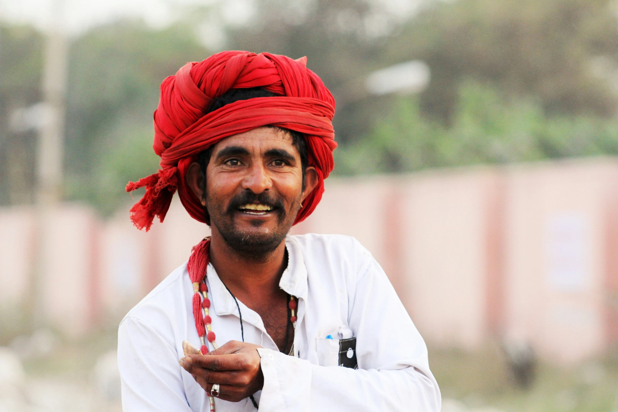 a man in a turban stands on his knees and points