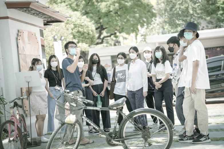 several young people are lined up together to take pos with their bicycle