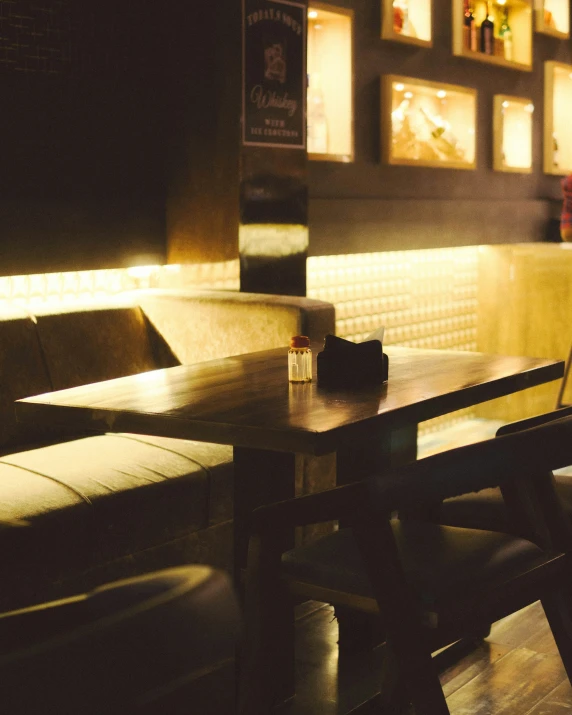 the dimly lit lounge room features booths and seating