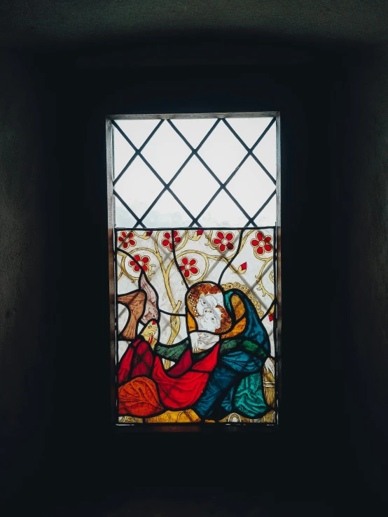 an old stained glass window depicting a person being taken by a baby