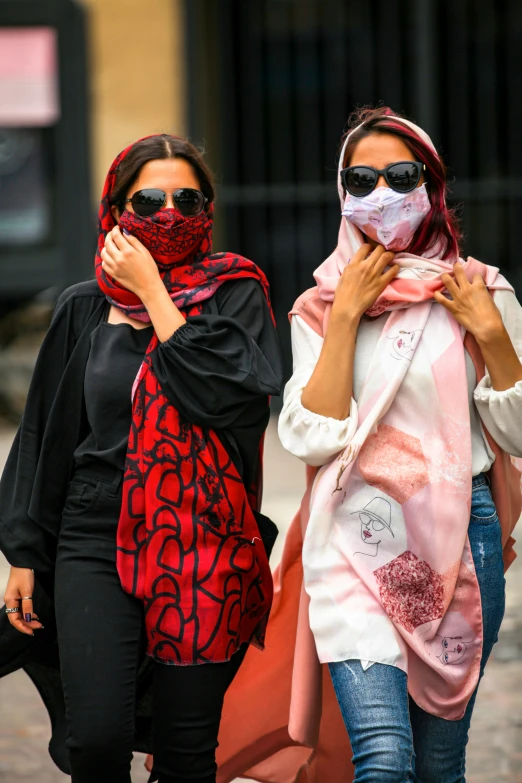 a couple of women walking down the street together