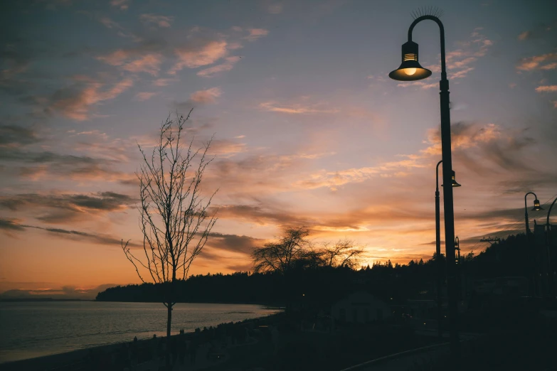 a street light with a beautiful sunset and clouds