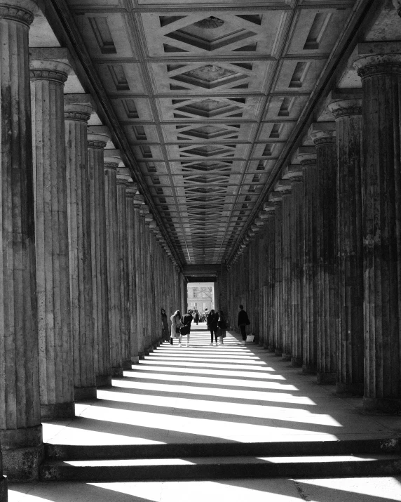 an empty walkway between two buildings is shown in black and white