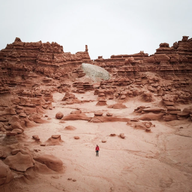 a lone woman in a large rocky desert area