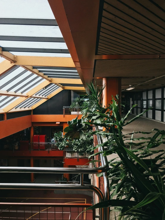 interior of a building with a balcony, plants, and stairwell
