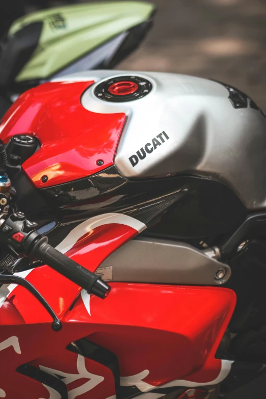 a red motorcycle parked on a sidewalk next to other motorcycles