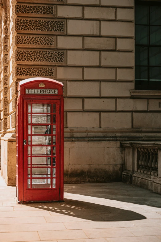 a red telephone booth on the side of a building