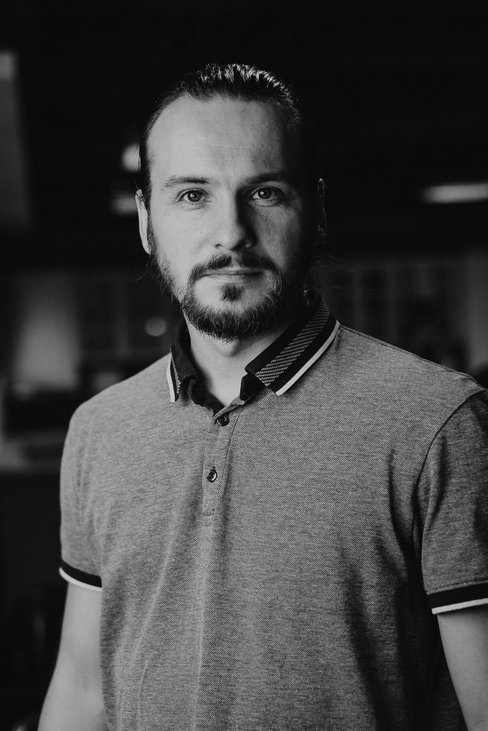 a man with a beard standing in front of shelves