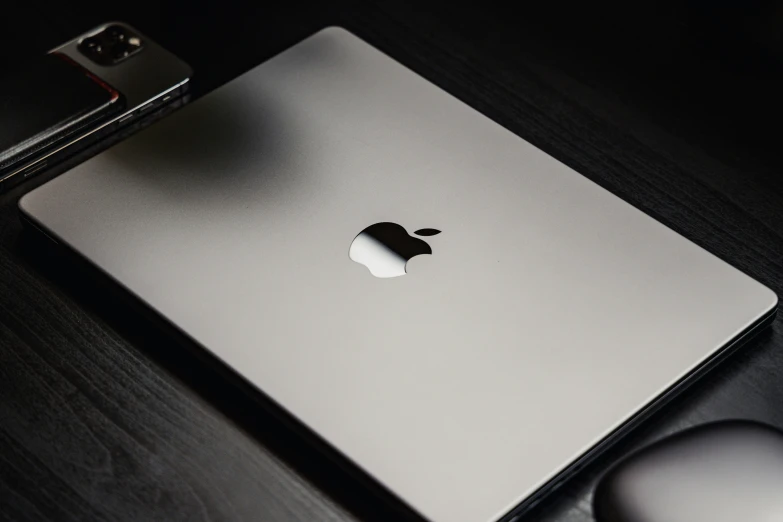 an apple laptop on the table with a mouse