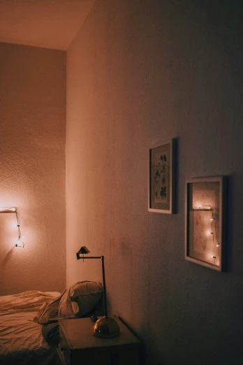 a bed sitting next to two framed pictures in a dark room