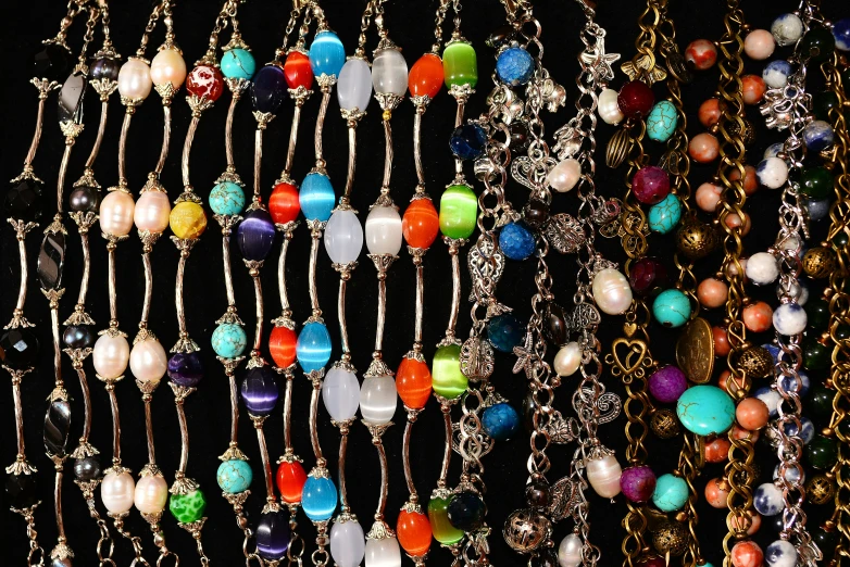 a variety of different necklaces hanging from chains