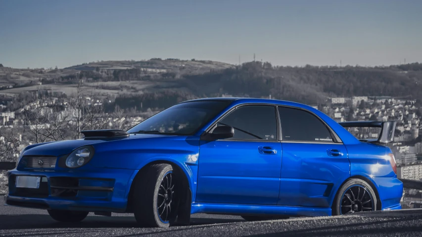 a blue car is parked on the side of the road