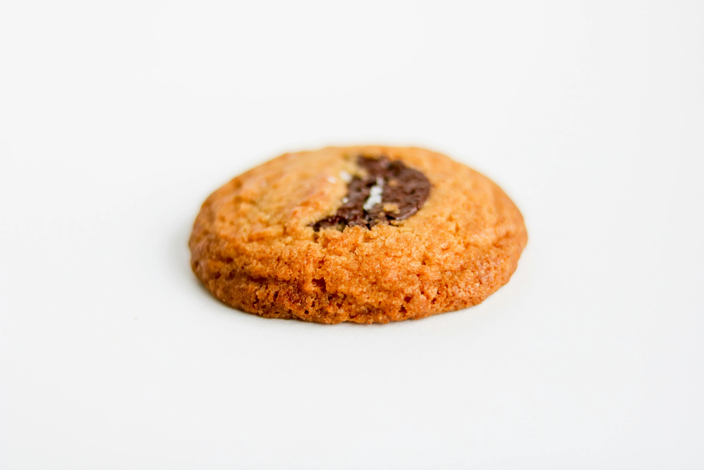 a chocolate chip cookie on a white surface