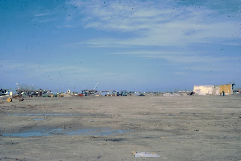 boats sit in an open dry land with lots of water