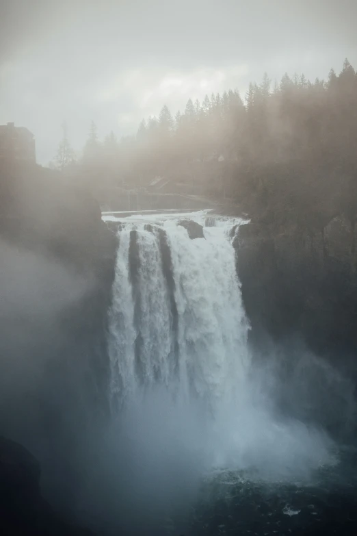 the side of a waterfall with trees behind it